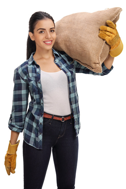 Happy female holding burlap sack on her shoulder - Фото, изображение