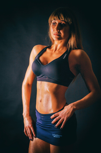 sexy Fitness-Frau auf dunklem Hintergrund. - Foto, Bild