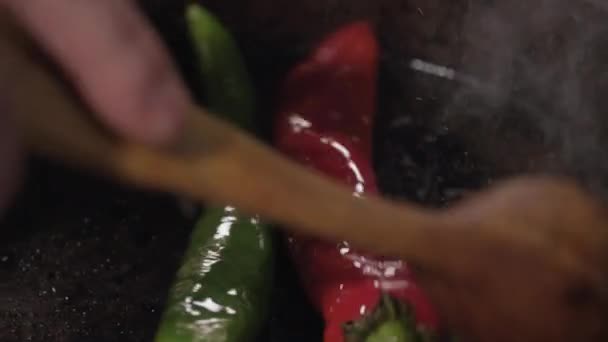 Close-up of red and green pepper on a pan - Felvétel, videó