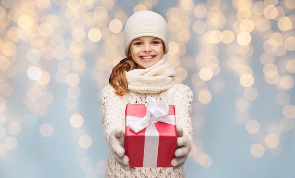 smiling girl in winter clothes with christmas gift - Foto, afbeelding