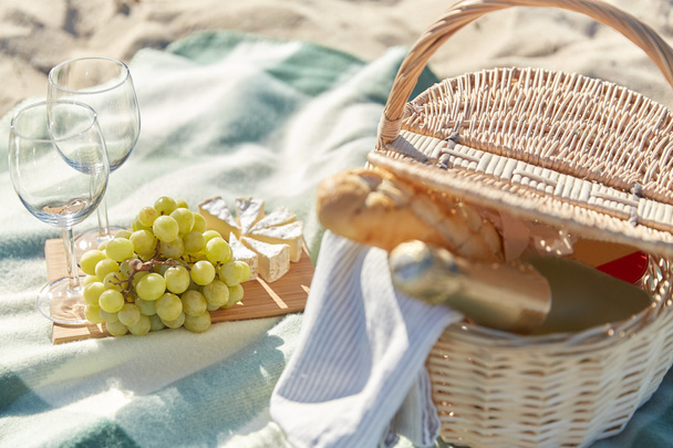 picnic basket with wine glasses and food on beach - Foto, Bild