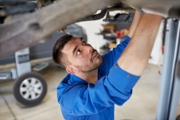 mechanic man or smith repairing car at workshop - Zdjęcie, obraz