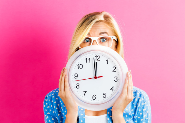 Woman holding clock showing nearly twelve - Foto, Bild