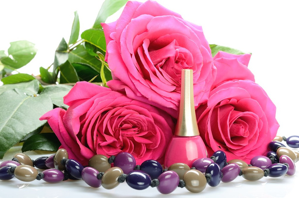 Trois roses roses et un vernis de soin des ongles, des perles
 - Photo, image