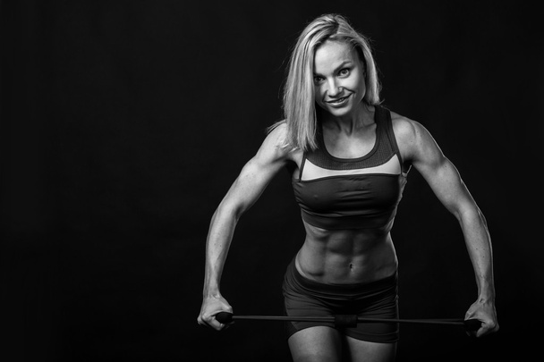 Vrouwelijke fitness op een donkere achtergrond. - Foto, afbeelding