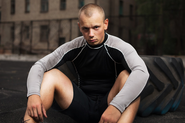 athlete sits at the tire, fatigue - Valokuva, kuva