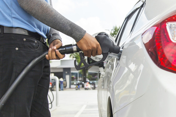 Hand refilling the car with fuel - Фото, изображение