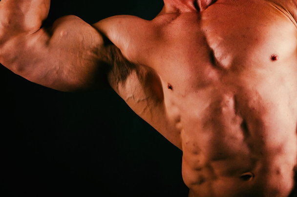 黒の背景に健康な筋肉体ボディービルダー - 写真・画像