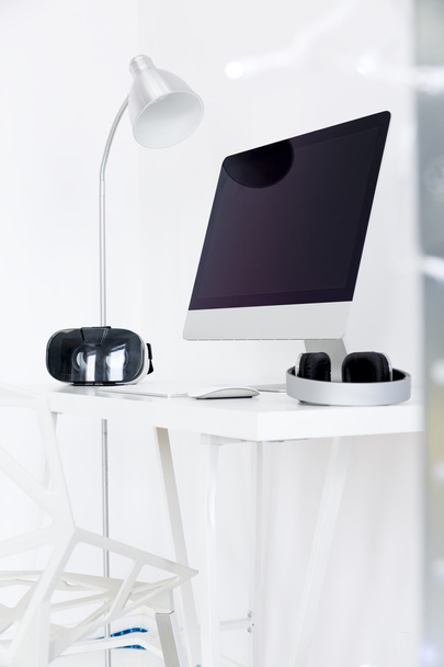 Escritorio moderno con pantalla de monitor y auriculares
 - Foto, Imagen