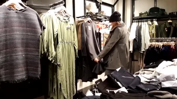Young woman chooses clothes - Footage, Video