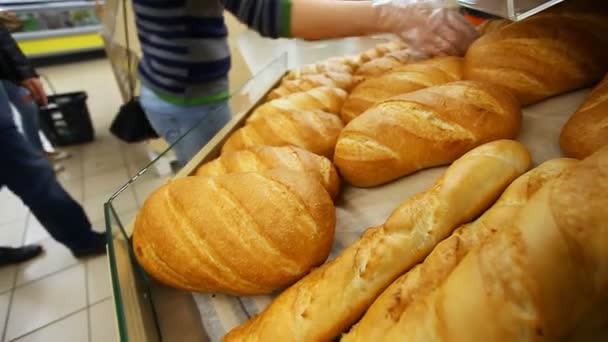 αγοραστής επιλέγει φρέσκο ψωμί σε ένα σούπερ μάρκετ - Πλάνα, βίντεο
