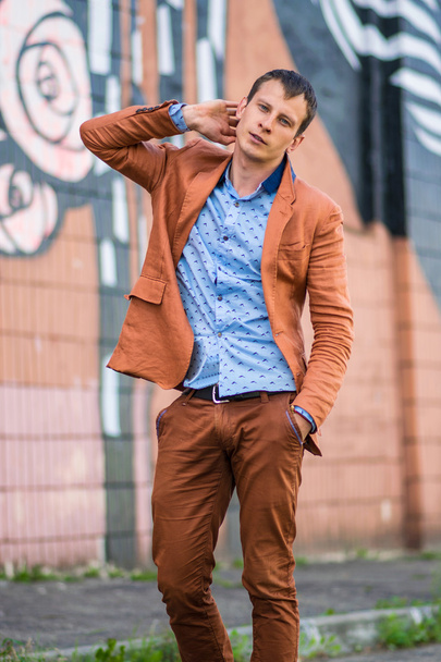 Cool fashion man in blue shirt standing and looking away. - Fotó, kép