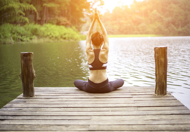 Joven mujer sana practicando yoga en el puente en la naturaleza
 - Foto, imagen