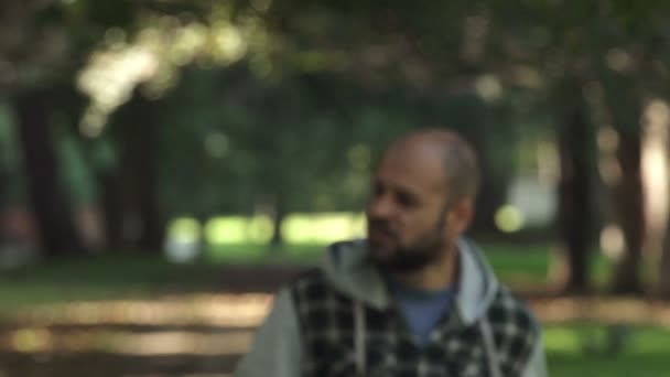 sad blurry man walking alone in a park - Πλάνα, βίντεο