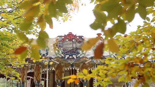 Hojas amarillas de otoño con tiovivo en el fondo
 - Imágenes, Vídeo