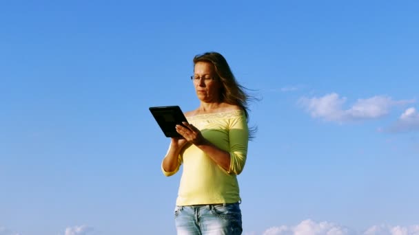 4 k. volwassen harmonous serios vrouw met Tablet PC- en blue sky - Video
