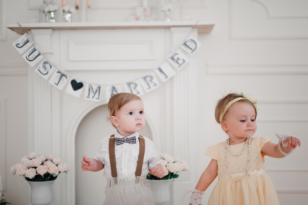 Hochzeit zweier Babys - Junge und Mädchen als Braut und Bräutigam verkleidet - Foto, Bild