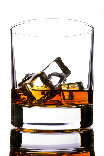Glass of whiskey and ice on a white background - Valokuva, kuva