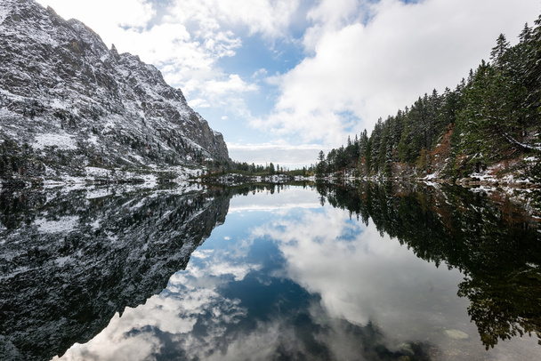 Réflexions dans l'eau calme du lac avec neige et montagnes
 - Photo, image