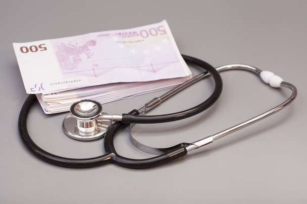 stethoscope with euro banknotes isolated on gray - Fotó, kép