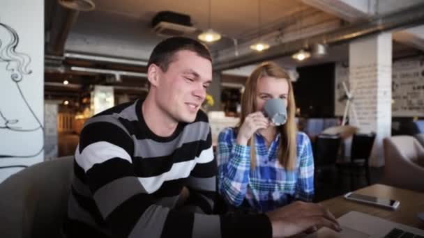 Twee vrienden zitten in Cafe, praten, drinken koffie en het gebruik van laptop - Video