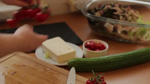Female hands cutting tomato on the wooden cutting board - Materiał filmowy, wideo