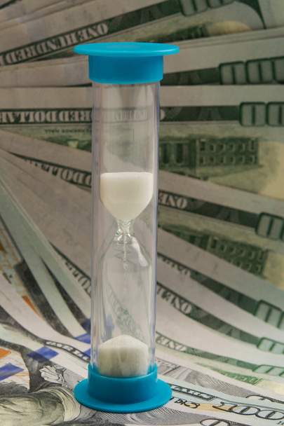 hourglass on the background of dollar bills - Foto, imagen