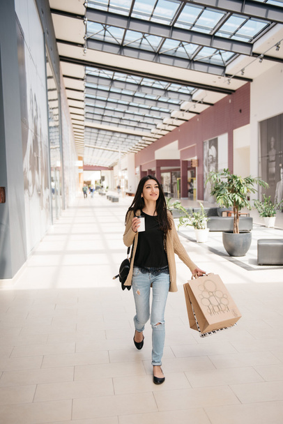 Attractive cute girl in with the shopping bags and warm drink in her hand - Foto, Imagen