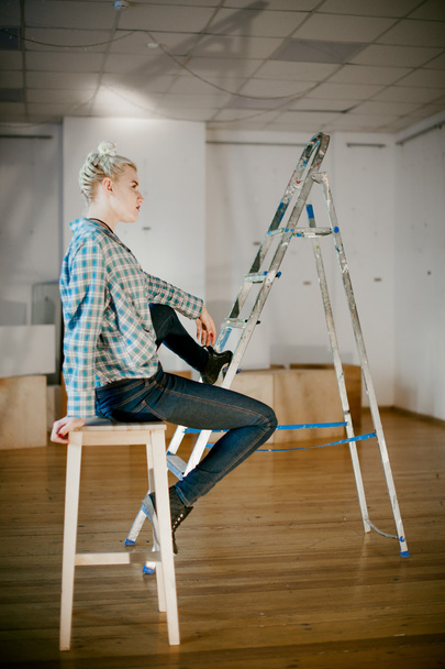 girl and construction ladder. studio shot of a young woman with a construction ladder in the room - Foto, afbeelding