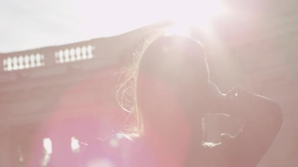 bezauberndes Mädchen, das ihr Haar in einem Sonnenstrahl berührt - Filmmaterial, Video