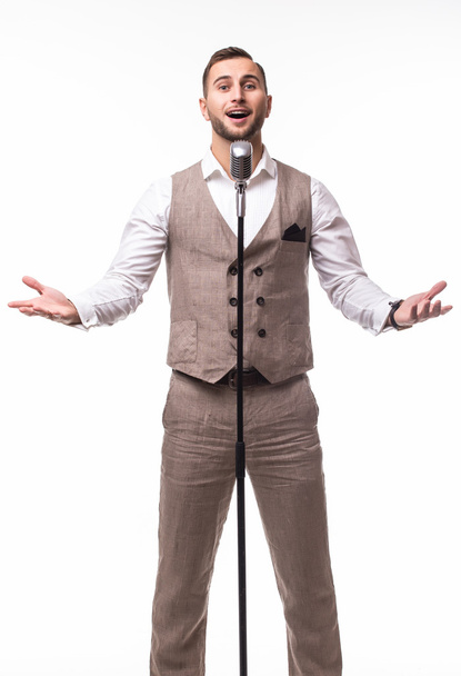 πορτρέτο του νεαρός άνδρας στο κοστούμι τραγουδώντας για το μικρόφωνο - Φωτογραφία, εικόνα