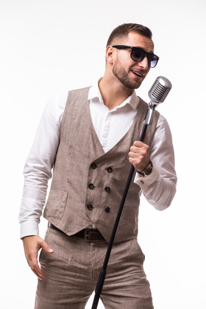 portrét mladého muže v obleku zpěv s mikrofonem - Fotografie, Obrázek