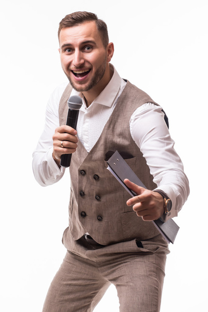 Jeune homme en costume chantant au micro avec énergie
. - Photo, image