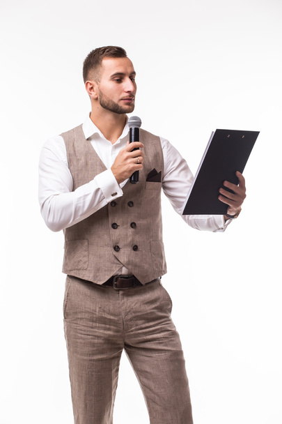 Молодой человек в костюме с энергией поет над микрофоном. - Фото, изображение