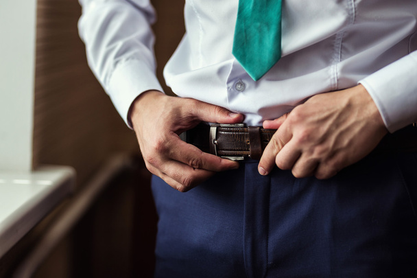 man putting on a belt, Businessman, Politician, man's style, male hands closeup, American businessman, European businessman, a businessman from Asia, People, business, fashion and clothing concept - Photo, Image