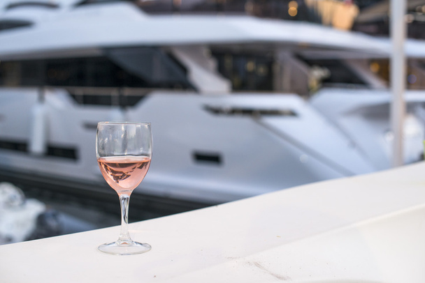 Glass of wine and a yacht - Valokuva, kuva