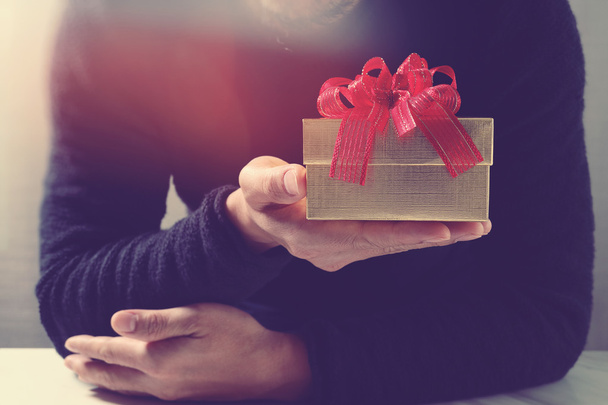 regalo, mano de hombre sosteniendo una caja de regalo en un gesto de giving.b
 - Foto, imagen