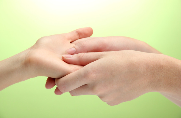Hand massage, on green background - Foto, imagen