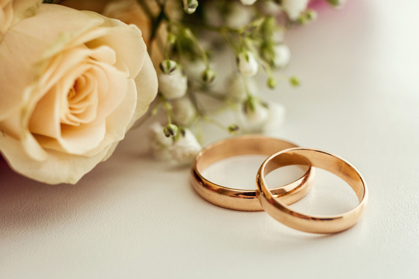 wedding rings lie on a beautiful wedding bouquet, wedding rings lie on a roses, bridal accessories, European Wedding, American Wedding - Φωτογραφία, εικόνα