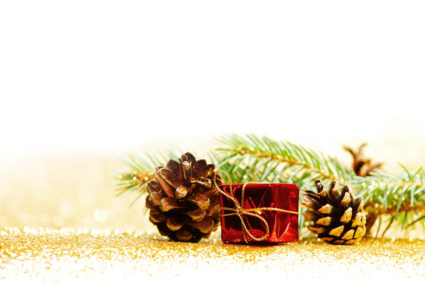 Christmas card with fir branch and decorations on golden gitter background - Photo, image