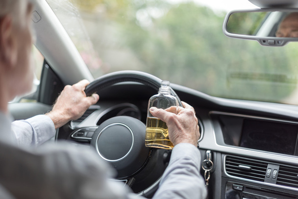 Hombre bebiendo alcohol y conduciendo
 - Foto, imagen