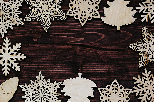 Christmas soft beige wooden snowflakes on a vintage wood brown  background.  - Фото, изображение