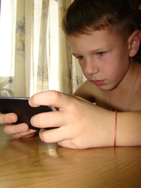 uma criança brincando ao telefone
 - Foto, Imagem