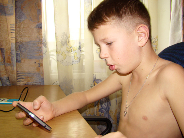 un niño jugando por teléfono
 - Foto, Imagen