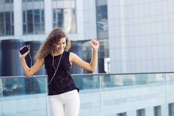 Curly girl listening to music and dancing - Photo, Image