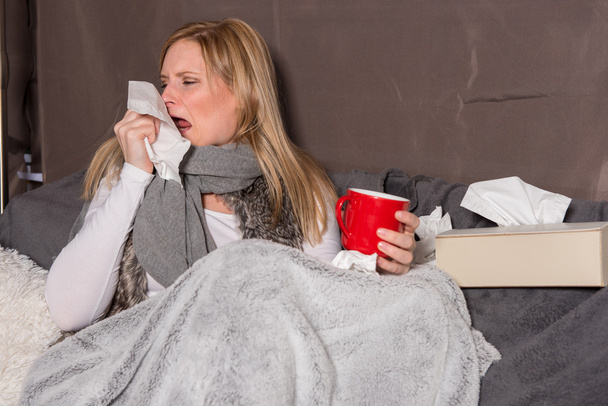 Mujer atractiva con estornudo frío en un pañuelo
 - Foto, imagen