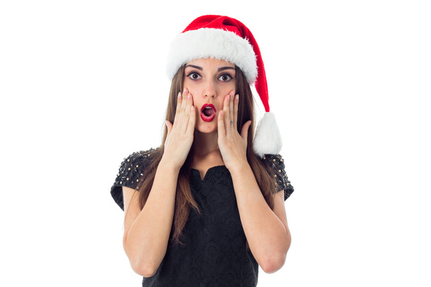surprised brunette girl in santa hat - Photo, image