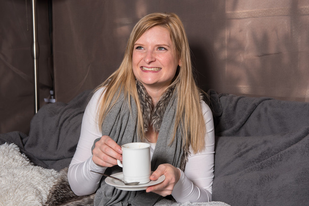 Attractive woman looking forward to her hot drink from the cup - Fotó, kép