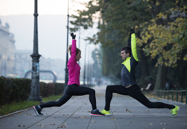 a young couple warming up before jogging - Foto, imagen