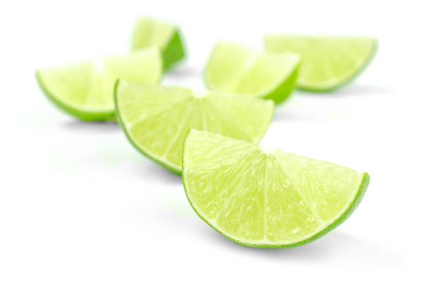 Scattering of fresh lime wedges isolated on a white background - Photo, Image